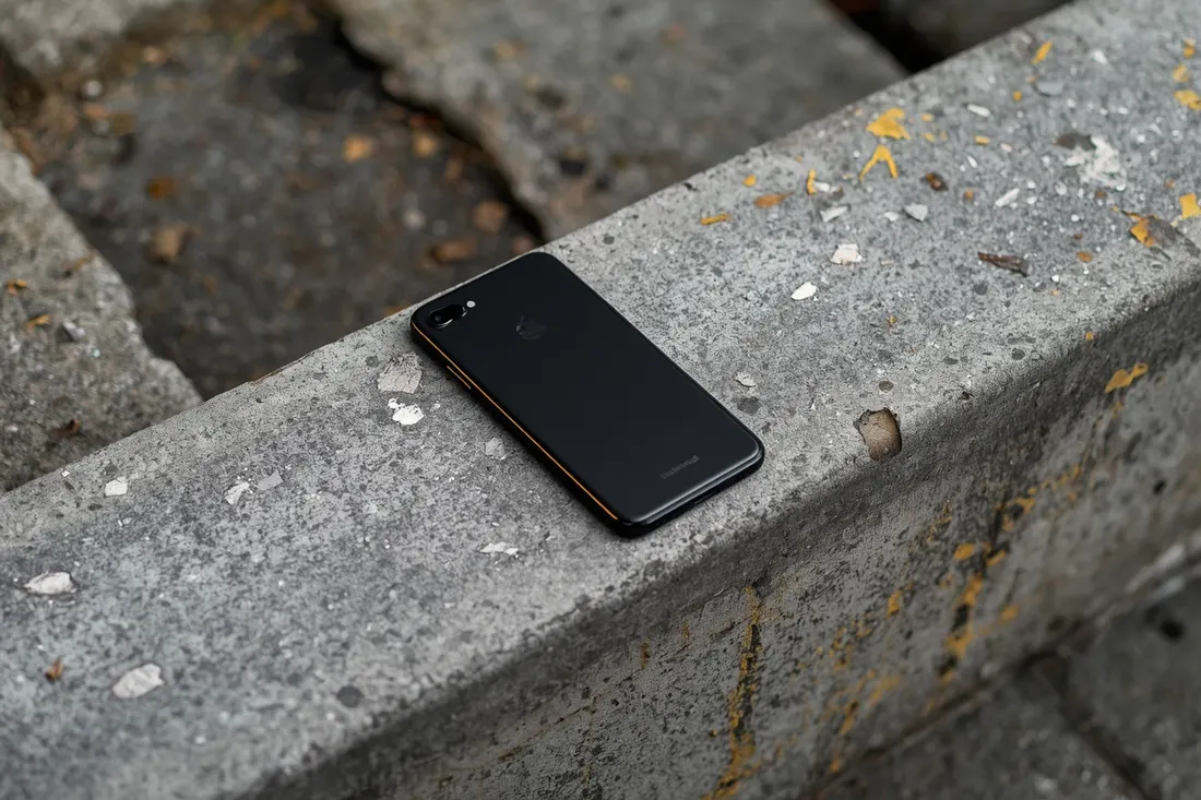 Smartphone mit dem Display nach unten auf einer Betonstufe
